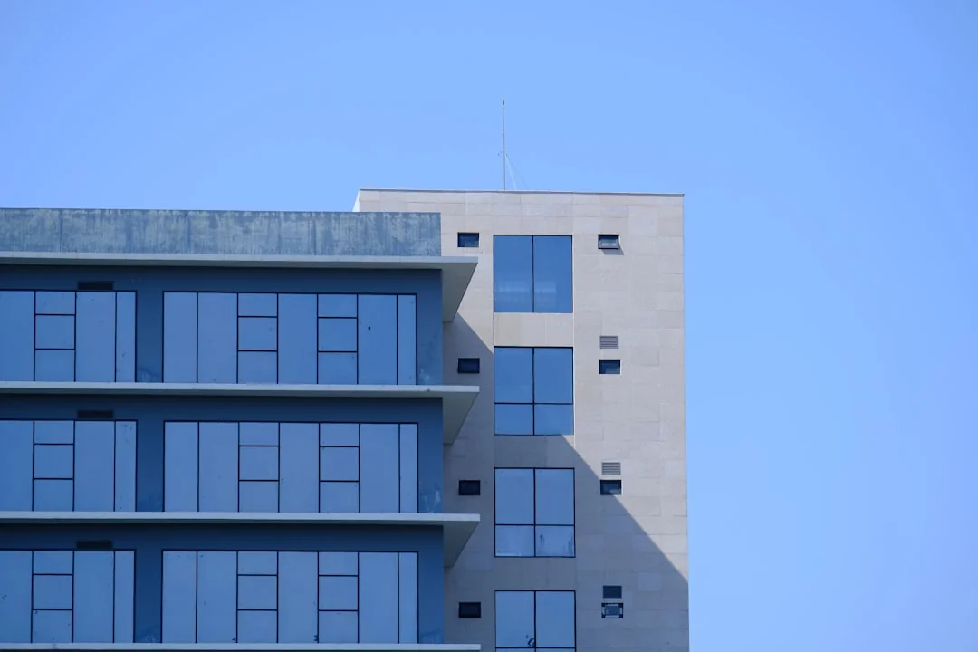 Professional window cleaners working on a skyscraper in Abu Dhabi, showcasing urban architecture.